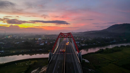Aerial view of the Kalikuto Bridge, an Iconic Red Bridge at Trans Java Toll Road, Batang when sunrise. Central Java, Indonesia, July 1, 2021