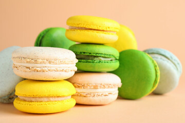 Delicious fresh colorful macarons on beige background, closeup