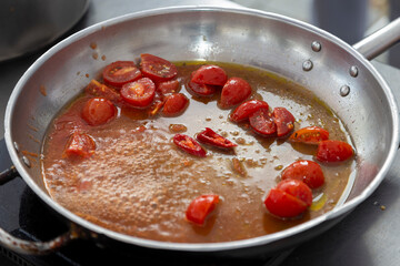 The process of cooking original Italian pasta in a pan with tomatoes and herbs. preparing an Italian penne pasta addict tomato sauce on a pan. The concept of italian cooking recipe
