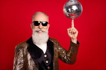 Photo of senior man happy positive smile spin disco ball finger concert showman isolated over red...