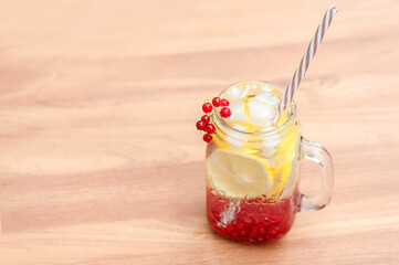 Summer cool drink to quench thirst from lemon and currant with ice cubes on the table . Summer background 