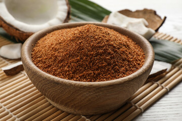 Natural coconut sugar in bowl on white wooden table