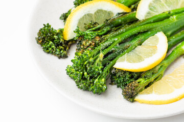 Cooked fresh broccolini with lemon on the plate