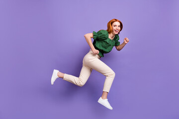 Fototapeta na wymiar Photo of sweet impressed young lady wear green blouse jumping high running fast isolated purple color background