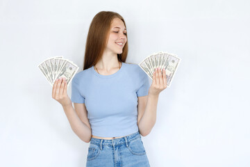 Happy girl with money in a blue T-shirt on a gray background