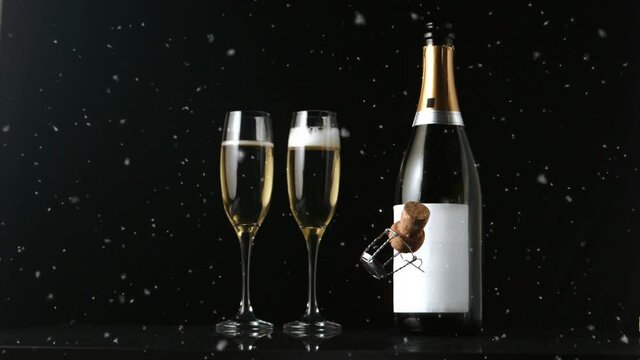 Animation of champagne bottle, two champagne glasses and cork falling