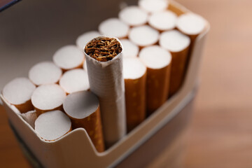 Pack of cigarettes on blurred background, closeup