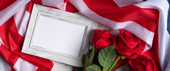 Concept of Independence day or Memorial day. Flag and rose over bright marble table background.