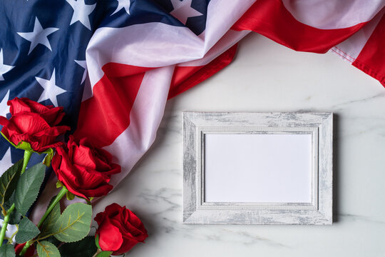 Concept of Independence day or Memorial day. Flag and rose over bright marble table background.