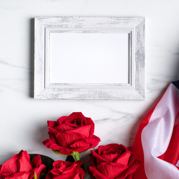 Concept of Independence day or Memorial day. Flag and rose over bright marble table background.