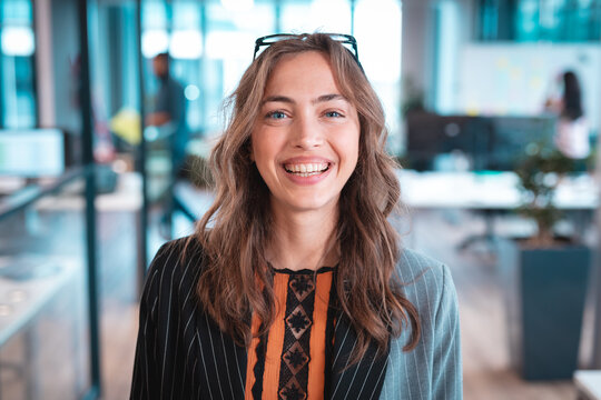 Portrait of caucasian businesswoman smiling and looking at camera with colleagues in background