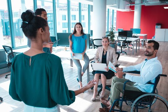 Group of diverse businesspeople discussing together and holding documents