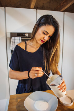 Woman with plain yogurt in house kitchen