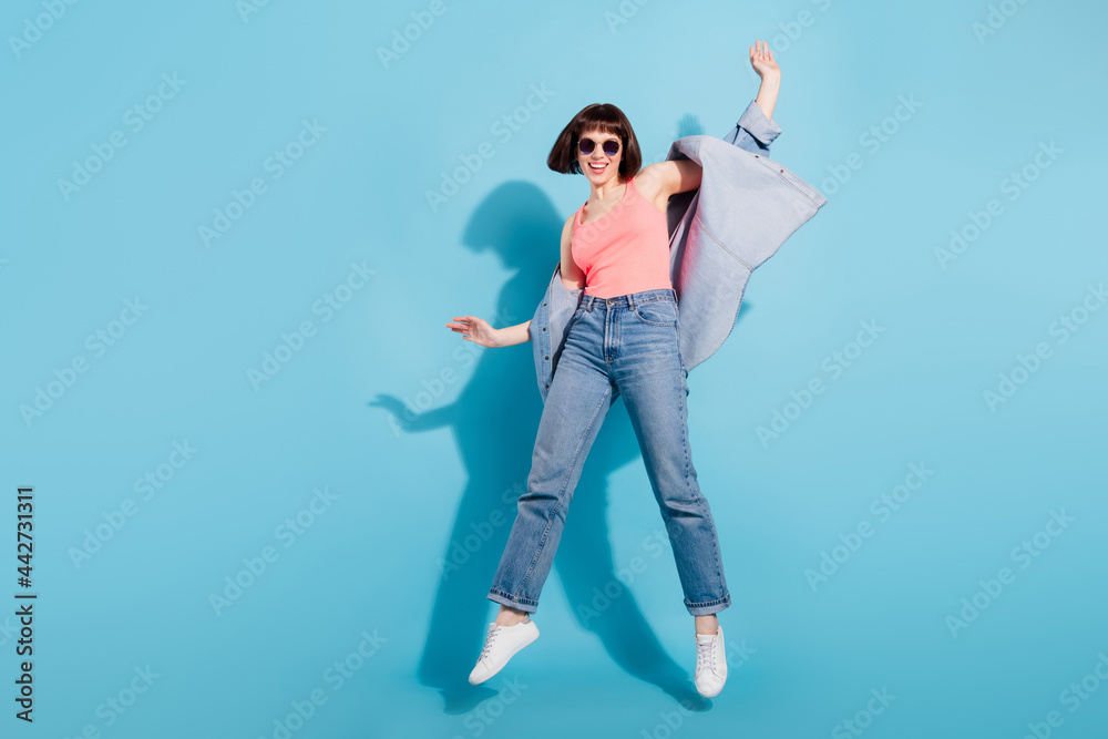 Canvas Prints Full size photo of sweet young lady jump wear top jeans eyewear isolated on blue color background