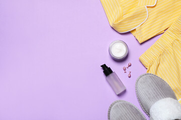 Obraz na płótnie Canvas Flat lay composition with pajamas and skin care products on violet background, space for text