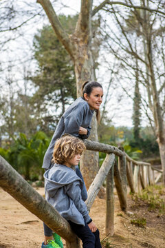 Smiling mom with son admiring nature in park