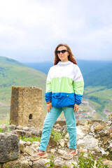 Naklejka premium Young woman girl traveller smiling and hiking in the mountains in Caucasus. Freedom lifestyle.