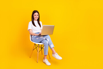 Fototapeta na wymiar Full size profile side photo of young woman happy smile sit chair work laptop chat type email isolated over yellow color background