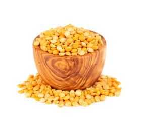 Dry yellow split peas in olive bowl, isolated on white background. Halves of yellow legume peas.
