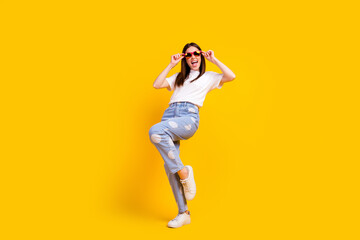 Fototapeta na wymiar Full body photo of young excited girl happy positive smile hipster hands touch sunglass isolated over yellow color background