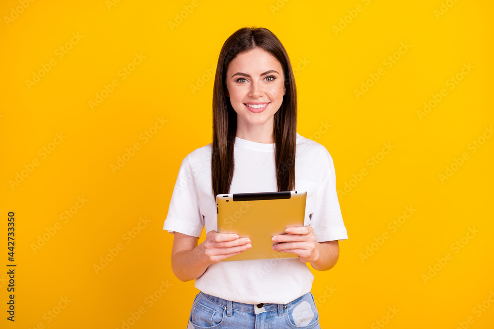 Sticker photo of young girl happy positive smile hold tablet gadget virtual isolated over yellow color backg