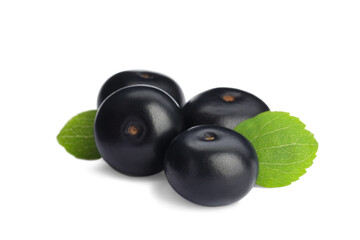 Pile of fresh ripe acai berries and green leaves on white background
