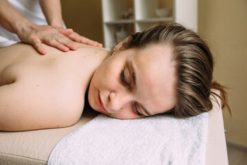 Fototapeta na wymiar Massage therapist doing massage on the female body in the spa.