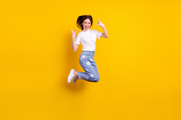 Full length profile side photo of young girl happy positive smile jump up show rock sign isolated over yellow color background
