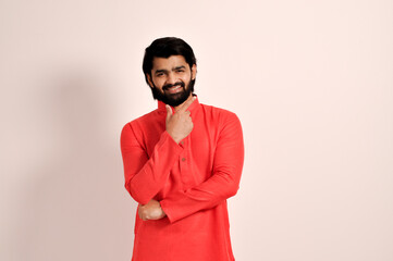 handsome Indian man wearing kurta and smiling with fingers near face