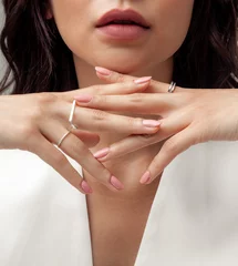 Poster Beautiful young girl on white vest posing hand wearing rings and jewellery © duyviet