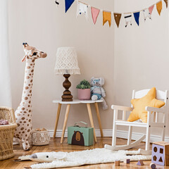 Stylish scandinavian interior of child room with mock up frame ,natural toys, hanging decoration, design furniture, plush animals, teddy bears and accessories. Interior design of kid room. Template. © FollowTheFlow