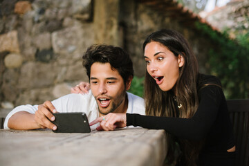 young couple looking at mobile while having fun