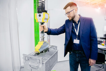 Worker engineer uses intelligent industrial manipulator lift easy with gripper in factory