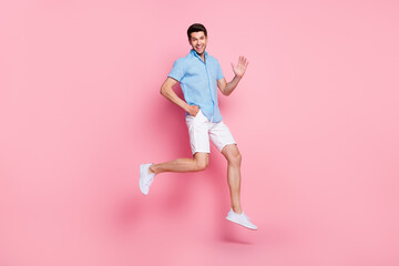 Fototapeta na wymiar Full length body size photo man jumping in summer clothes waving hand isolated pastel pink color background