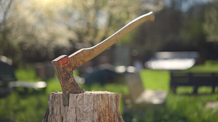 Man in plaid shirt and straw hat is chopping wood in garden at sunny spring day shot in 4k super slow motion