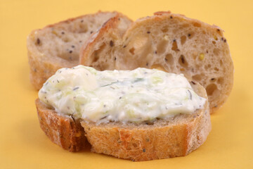 Tartine de tzatziki en gros plan sur fond jaune