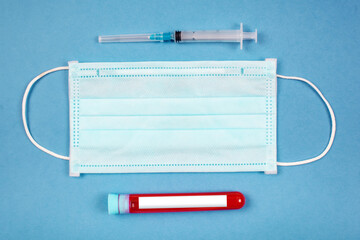 Medical mask and test tube with blood on a blue background. Healthcare medical. top view.