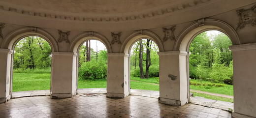 Music Pavilion from the inside, through the arches you can see the trees and grass in the park on Elagin Island in St. Petersburg.