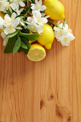 Flowering jasmine, mint, and lemons on a wooden background.