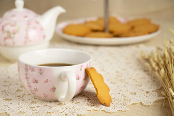 Cup of tea next to cookies on table. afternoon tea