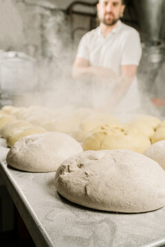 Crop ethnic baker preparing bread at work