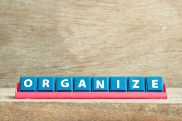 Tile letter on red rack in word organize on wood background