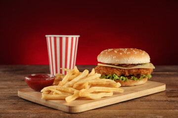 Delicious fast food menu on wooden table against red background