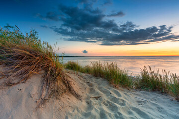 A beautiful sunset on the beach of the Sobieszewo Island at the Baltic Sea. Poland - obrazy, fototapety, plakaty