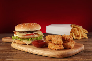 Delicious fast food menu on wooden table against red background