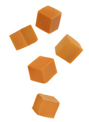 Delicious caramel cubes flying on white background