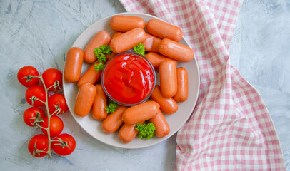 sausages with ketchup on a concrete background