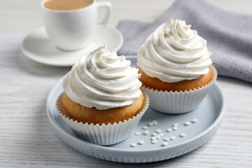 Obraz na płótnie Canvas Delicious cupcakes with cream on white wooden table, closeup