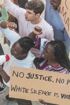 Company of diverse people protesting with posters on street