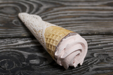 Waffle cones with marshmallows. On brushed pine boards.